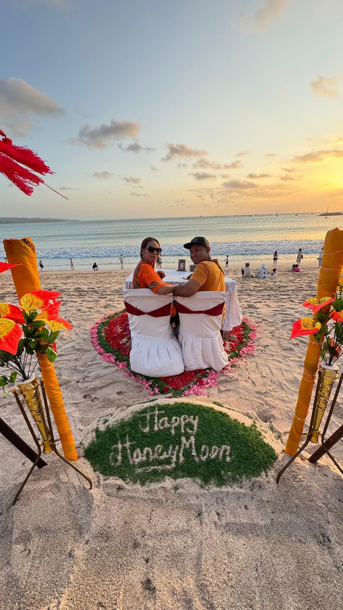 Romantic dinner pasangan honeymoon ketika matahari terbenam di Bali
