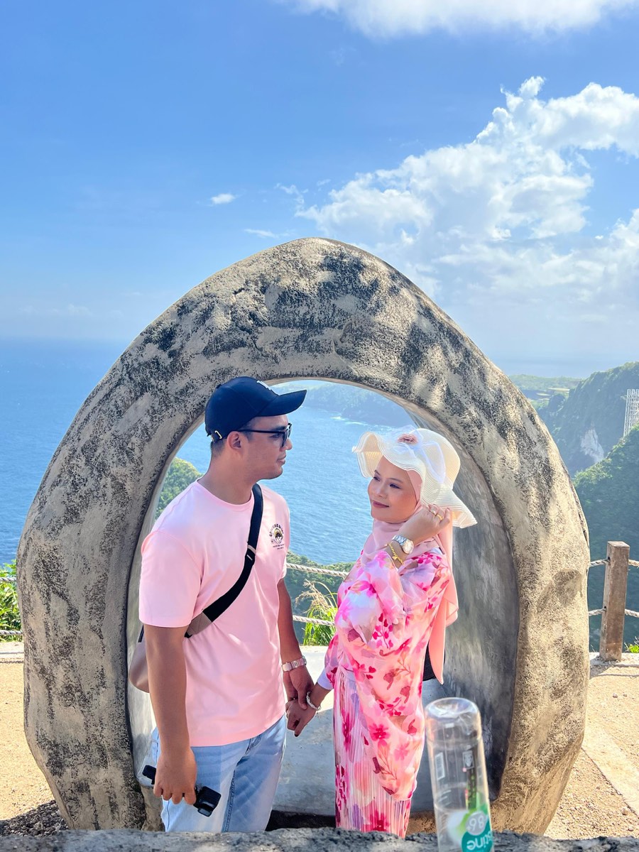 Pasangan honeymoon menikmati pemandangan laut Bali